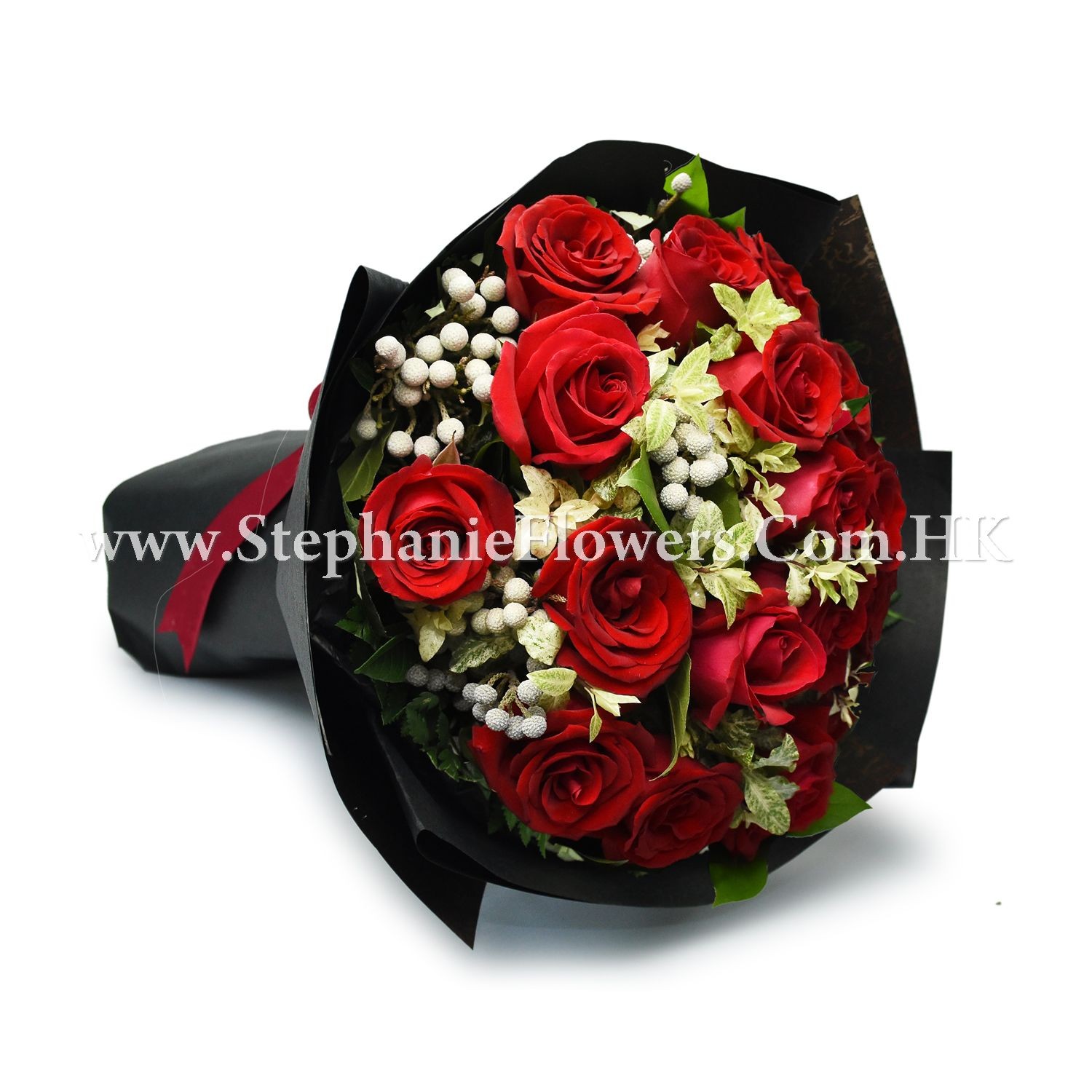 Bouquet of red roses and white berries wrapped in black paper.